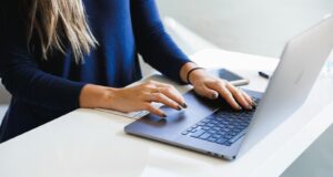 woman in blue long sleeve shirt using macbook pro