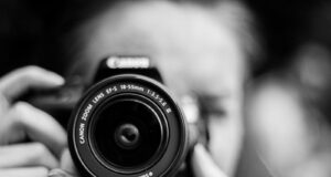person taking photo using Canon camera in shallow focus lens