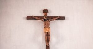 brown wooden cross on white wall