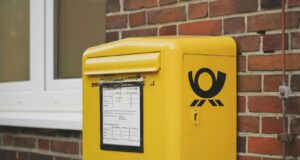 yellow mailbox on brown wall bricks