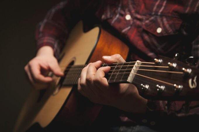 Photo by Gary Meulemans person playing brown acoustic guitar