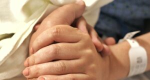 a close up of a person holding the hand of another person