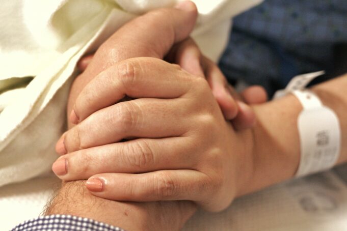 a close up of a person holding the hand of another person