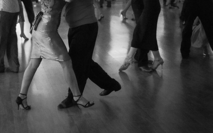 People are dancing on a wooden floor.