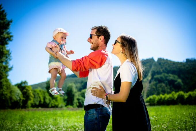 Photo by Ricardo Maruri man in white and red polo shirt carrying girl in blue denim jeans during daytime