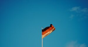 red white and yellow flag on pole under blue sky during daytime