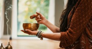woman in brown knit sweater holding brown ceramic cup