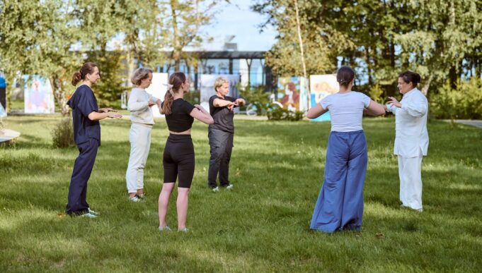Group qigong practice in sunny park setting