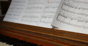 Sheet music rests on a wooden piano keyboard.