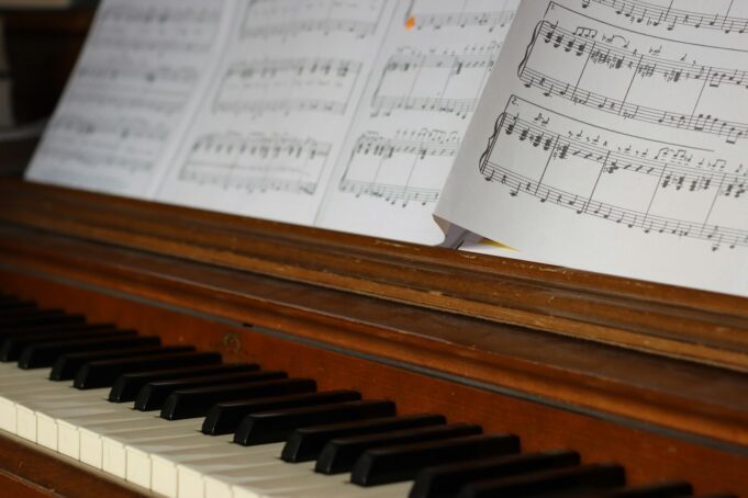 Sheet music rests on a wooden piano keyboard.