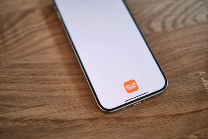 Photo by appshunter.io A cell phone sitting on top of a wooden table