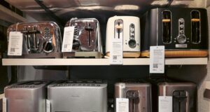 A bunch of toasters that are on a shelf