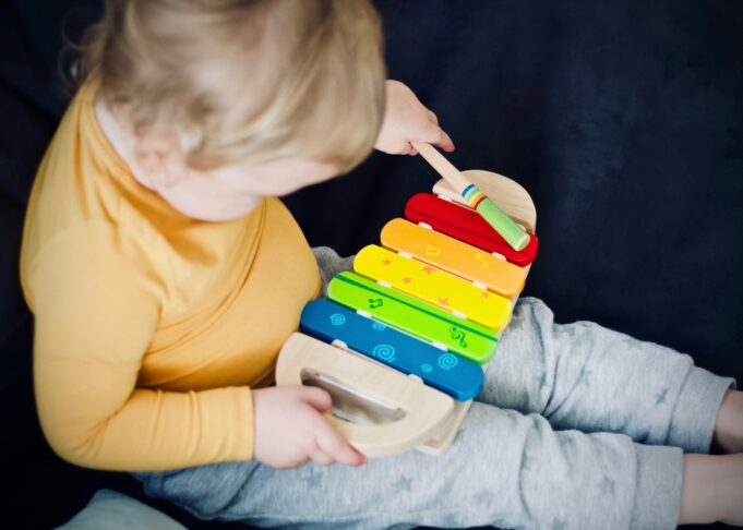 Photo by Jelleke Vanooteghem toddler playing wooden xylophone toy