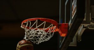 A basketball going through the hoop in a basketball court