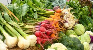 green and red vegetable on brown wooden table