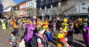 Menschen feiern beim Faasenachtsumzug 2025 in St. Ingbert